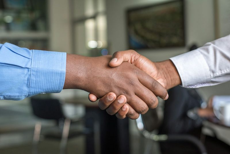 Zwei Menschen geben sich die Hand